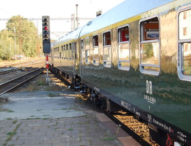 Außenansicht der Wagons. Der Zug steht am Bahnsteigende mit Signalanlage.