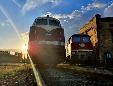 Bild einer roten Diesellok im Sonnenuntergang